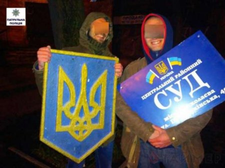 Сувенир: в Николаеве двое мужчин сорвали со здания Центрального суда герб Украины